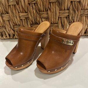 Wooden leather clogs with stud detail by Coach.